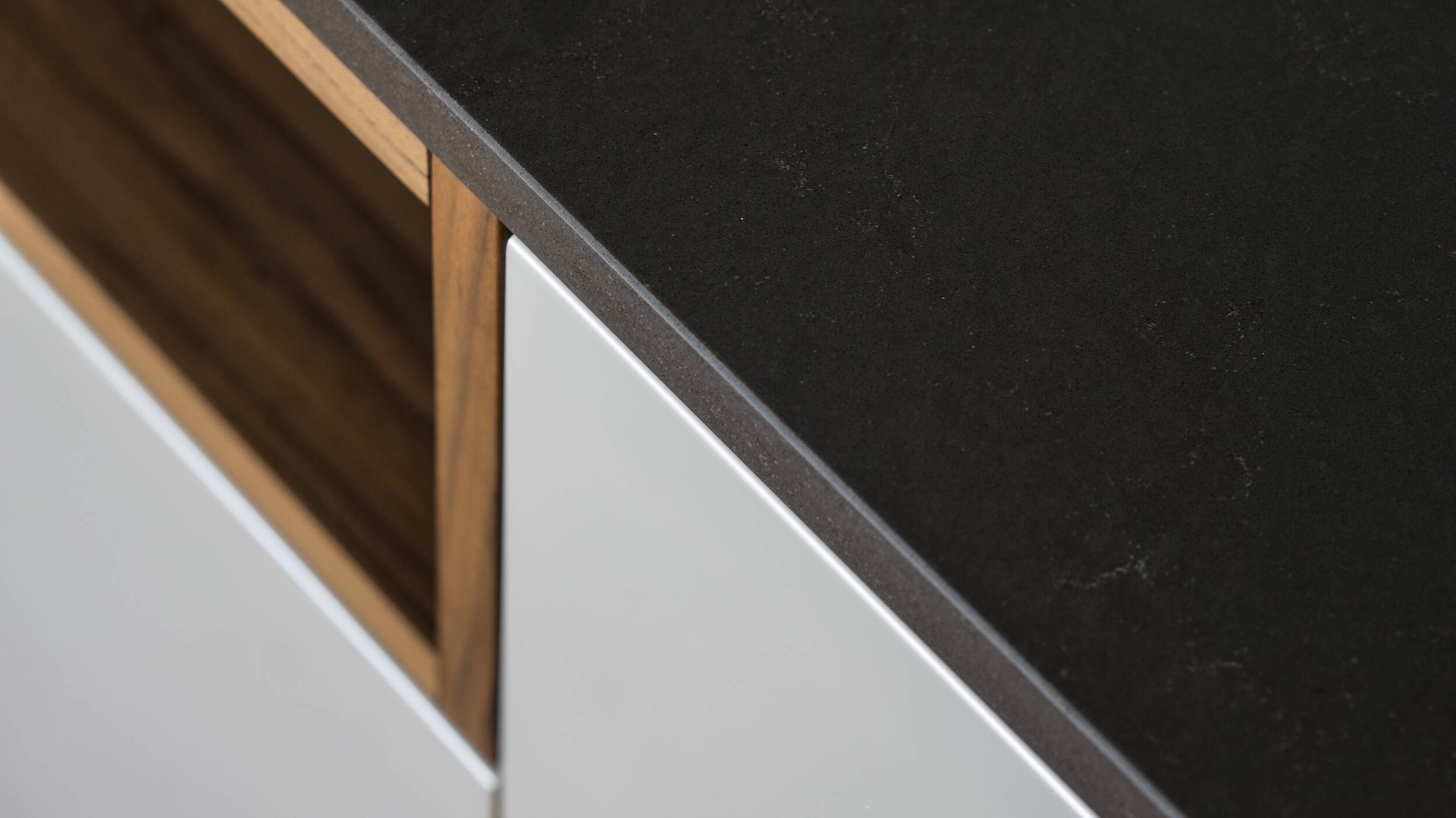 Referenz Hugentobler AG aus Branau, Wil - Im Detail ist die gefaste Kante der Silestone Merope Oberfläche mit Holzschublade und weisser Front zu sehen.